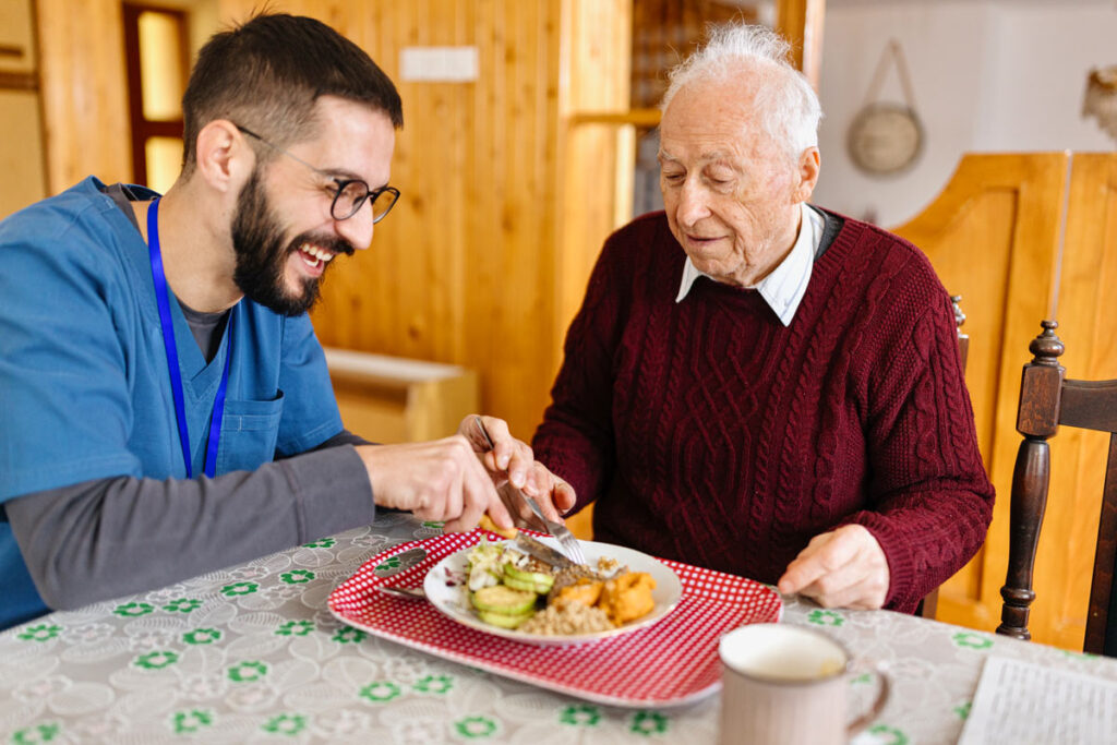 Caretaker helping man with meal